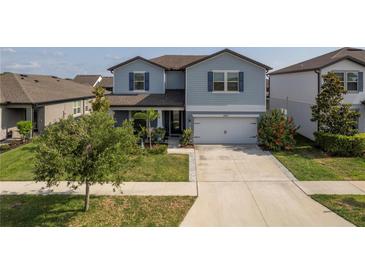 Charming two-story home with a well-maintained lawn and a two-car garage at 10313 Wine Press Ave, Riverview, FL 33578