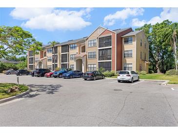 Three-story condo building with tan and rust colored facade and ample parking at 11901 4Th N St # 8207, St Petersburg, FL 33716