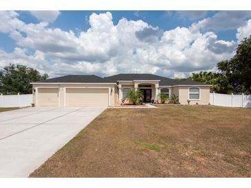 Charming single-story home with well-manicured lawn, three-car garage, and a welcoming entrance at 1521 Avondale Ridge Dr, Plant City, FL 33567