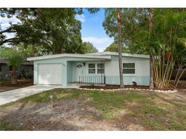Charming single-story home featuring a light blue and white exterior, complemented by a well-maintained front yard and mature trees at 341 Wertz Dr, Largo, FL 33771