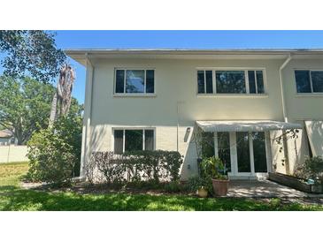 Two-story home with light-colored stucco, trimmed hedges, and an awning over the patio at 4560 Overlook Ne Dr # 168, St Petersburg, FL 33703