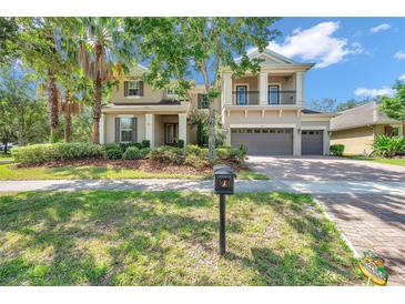 Inviting two-story home featuring a lush lawn, mature landscaping, and a spacious three-car garage at 5117 Longspur Ct, Lithia, FL 33547