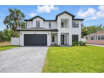 Modern two-story home featuring a manicured lawn and a black garage door at 816 W Orient St, Tampa, FL 33603