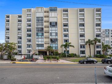 Multi-story condo building featuring balconies, lush landscaping, and convenient parking at 830 S Gulfview Blvd # 102, Clearwater Beach, FL 33767