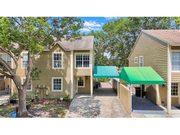 Two-story townhouse with siding and covered parking at 9050 Lake Place Ln, Tampa, FL 33634