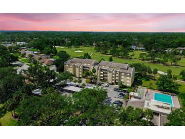 An aerial view of a condominium complex situated on a golf course near a swimming pool at 13618 Greenfield Dr # 105, Tampa, FL 33618