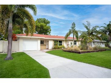 Charming single story home with a red tile roof, palm trees, an attached garage and well manicured lawn at 5 N Mercury Ave, Clearwater, FL 33765