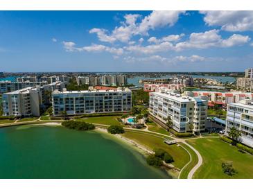Beautiful aerial view of a waterfront condo community featuring lush landscaping and a swimming pool at 7872 Sailboat Key S Blvd # 301, South Pasadena, FL 33707