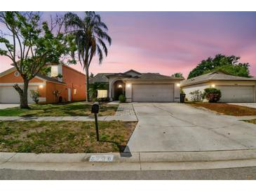 Charming single-Gathering home with a well-maintained lawn and a two-car garage, set against a dusk sky at 8736 Huntfield St, Tampa, FL 33635