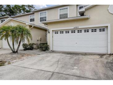 Townhouse features a two-car garage and well-maintained landscaping at 14985 Alan Ct, Largo, FL 33771