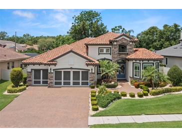 Stunning two-story home with a terracotta roof, lush landscaping, and brick driveway at 2142 Scarlet Oaks St, Clearwater, FL 33759