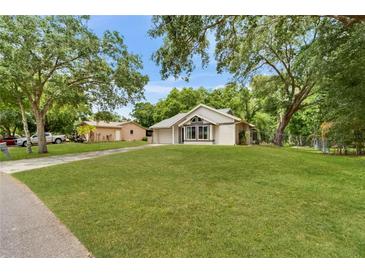 Charming single-story home with well-manicured lawn, mature trees, and a welcoming exterior at 23739 Forest View Dr, Land O Lakes, FL 34639