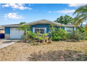 Charming blue home featuring a one car garage and a stone accent wall at 3621 Beacon Square Dr, Holiday, FL 34691