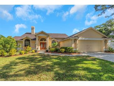 Charming single-story home with a well-manicured lawn and beautifully landscaped garden beds at 3908 Lithia Ridge Blvd, Valrico, FL 33596