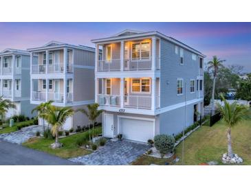 Beautiful two-story home featuring dual balconies, well-kept landscaping, and a paved driveway leading to a garage at 4357 Marina View Way, Cortez, FL 34215