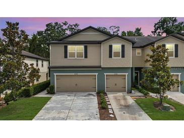 Charming two-story townhomes with individual garages, lush landscaping, and well-maintained driveways at 5344 Sylvester Loop, Tampa, FL 33610