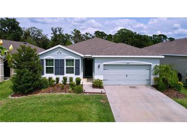 Charming single-story home with a well-manicured lawn and a two-car garage at 8214 Wheat Stone Dr, Zephyrhills, FL 33540