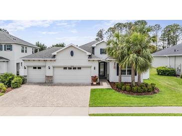 Charming home featuring a three-car garage, well-manicured lawn, and tropical palm trees adding curb appeal at 19608 Lonesome Pine Dr, Land O Lakes, FL 34638