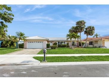 Charming single-story home featuring a two-car garage, lush lawn, and inviting curb appeal at 2146 Waterside Dr, Clearwater, FL 33764