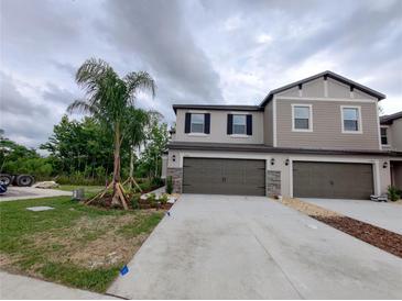 Beautiful townhome featuring neutral paint, well-maintained landscaping and an attached two-car garage at 23300 Willow Glen Way, Lutz, FL 33549