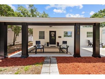 Inviting front porch with seating and decorative rug for a warm welcome at 708 53Rd N Ave, St Petersburg, FL 33703