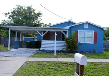 Charming blue home with covered parking and a well-manicured lawn and a small mailbox at 731 20Th Nw St, Largo, FL 33770