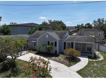 Charming single-Gathering home featuring a well-manicured lawn with vibrant pink flowers and a welcoming driveway at 116 S Arrawana Ave, Tampa, FL 33609