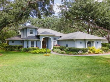 Stunning single-Gathering home featuring a lush lawn, mature trees and meticulous landscaping at 12002 Hope Ln, Tampa, FL 33618