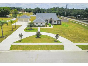 Aerial view of property featuring spacious lot, long driveway and well maintained landscaping at 13338 Jaudon Ranch Rd, Dover, FL 33527