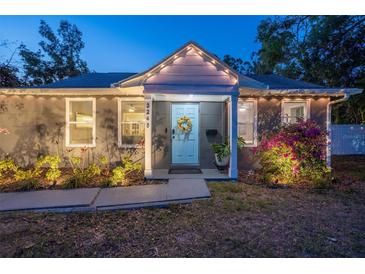 Charming single story home with a tidy landscaped yard and a decorative wreath on the front door at twilight at 3245 Freemont S Ter, St Petersburg, FL 33712