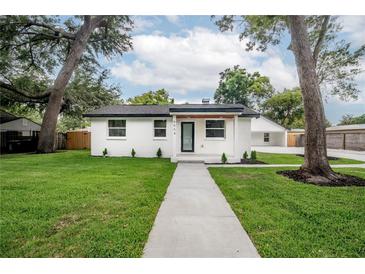 Charming home featuring a manicured lawn and fresh exterior paint at 6504 N 13Th St, Tampa, FL 33604