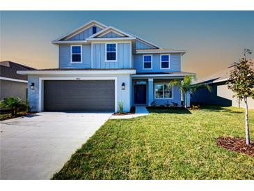 Charming two-story home boasts a manicured lawn, gray siding, and an attached two-car garage at 6807 162Nd Pl, Parrish, FL 34219