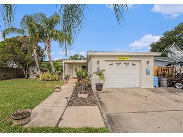 Charming single-story home with lush landscaping and a well-maintained front yard and a one car garage at 9616 56Th N St, Pinellas Park, FL 33782