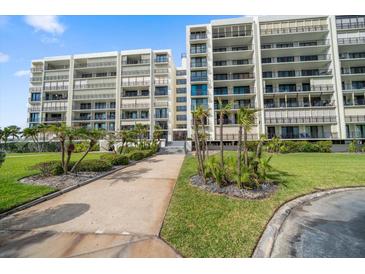Beautiful condo building with well-manicured landscaping and a walkway leading to the entrance at 1400 Gulf Blvd # 804, Clearwater Beach, FL 33767