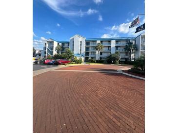 Condo building features a brick entry with parking and patriotic flags waving in the wind at 2424 W Tampa Bay Blvd # 203, Tampa, FL 33607