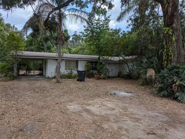 White brick single-story home featuring an attached carport and a driveway at 403 E Clay Ave, Brandon, FL 33510