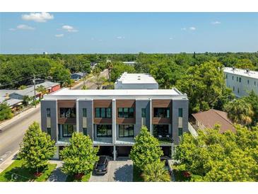 Modern townhome with clean lines, wood accents, landscaped front yard, and a view of lush greenery at 607 W Euclid Ave # 3, Tampa, FL 33602