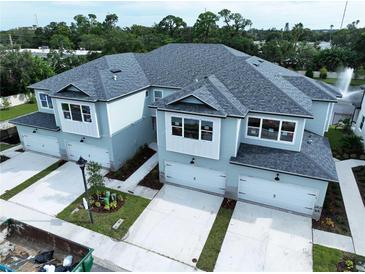 New townhomes featuring multiple garage doors, stone accents, and professionally landscaped grounds at 7798 93Rd N St # 1, Seminole, FL 33777