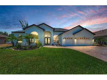 Stunning home featuring a well manicured lawn, brick paver driveway, and a fountain near the entrance at 9208 Brindlewood Dr, Odessa, FL 33556