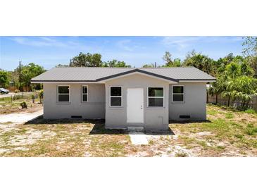 Charming single-story home with a new-looking metal roof and freshly painted light gray exterior at 11009 Spivey Rd # 1, Gibsonton, FL 33534