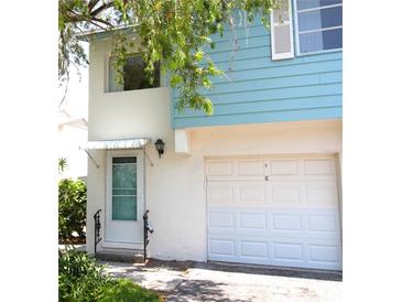 Charming two-story home featuring a one-car garage and front door, with mature trees adding to the curb appeal at 3276 38Th S Way # D, St Petersburg, FL 33711