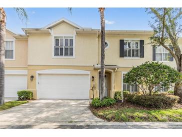 Charming townhome with a two-car garage, manicured landscaping, and a welcoming entrance at 3429 Heards Ferry Dr, Tampa, FL 33618