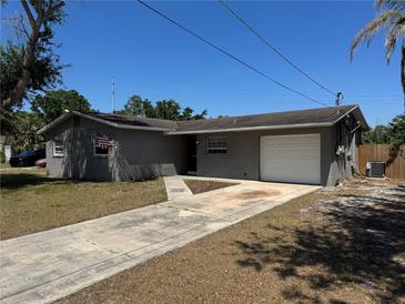 Charming single-story home featuring a one-car garage, gray brick exterior, and a well-manicured lawn at 5813 Oxford Dr, Tampa, FL 33615