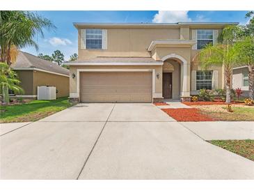 Two-story home with a two-car garage, landscaped yard, and inviting front entrance at 13174 Royal Pines Ave, Riverview, FL 33579