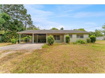 Charming single-story home featuring a carport, green landscaping, and a well-maintained lawn at 1609 S Valrico Rd, Valrico, FL 33594