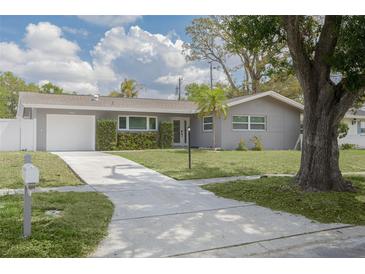 Charming single Gathering home featuring a well-manicured lawn, long driveway and attached garage at 1624 Chateau Dr, Clearwater, FL 33756