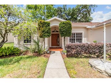 Inviting front entrance with a well-manicured lawn and beautiful landscaping, creating excellent curb appeal at 4915 Fort Peck Rd, New Port Richey, FL 34655