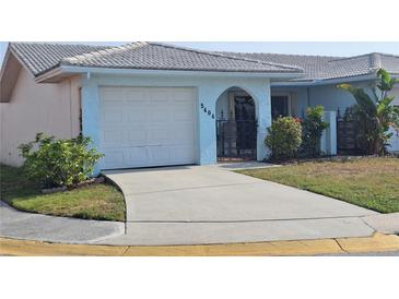 Quaint one-story home featuring an attached single car garage and wrought iron gated courtyard at 5404 Springwood Blvd # 5404, Pinellas Park, FL 33782