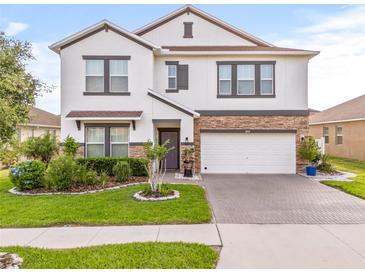 Charming two-story home featuring a well-maintained front yard and brick-paved driveway leading to a two-car garage at 3212 Calvano Dr, Land O Lakes, FL 34639