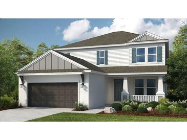 Charming two-story home featuring a landscaped yard, two-car garage, and inviting front porch at 33626 Castaway Loop, Wesley Chapel, FL 33543